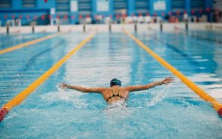 Young woman swimmer swims in swimming pool