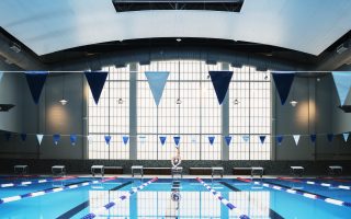 Man diving into indoor swimming pool.